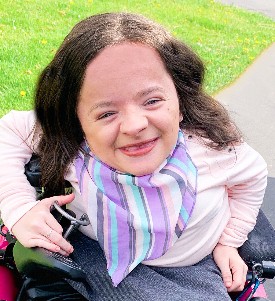 Michaela Davert smiling in pink shirt and striped scarf