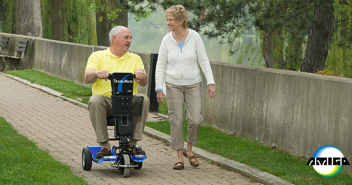 Male Amigo TravelMate user and wife walking down path in park