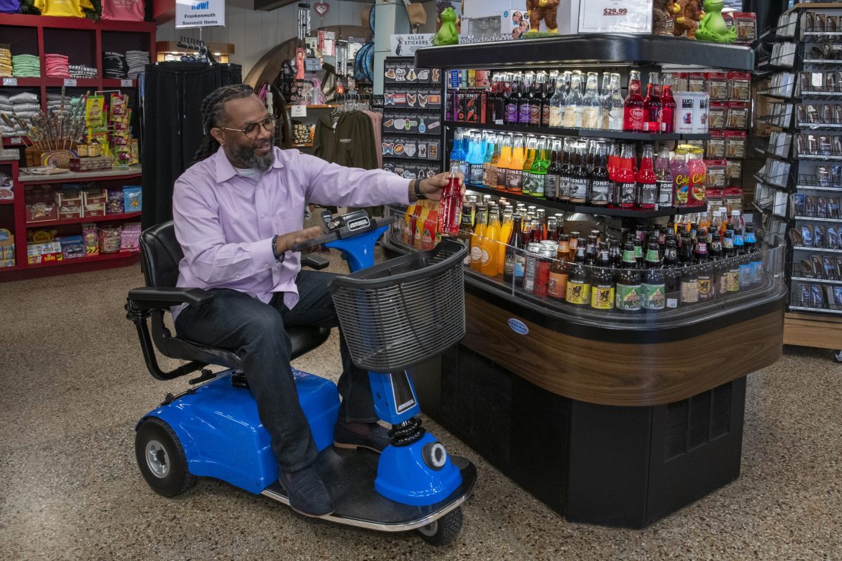 Man seated on an Amigo scooter shopping at a store.