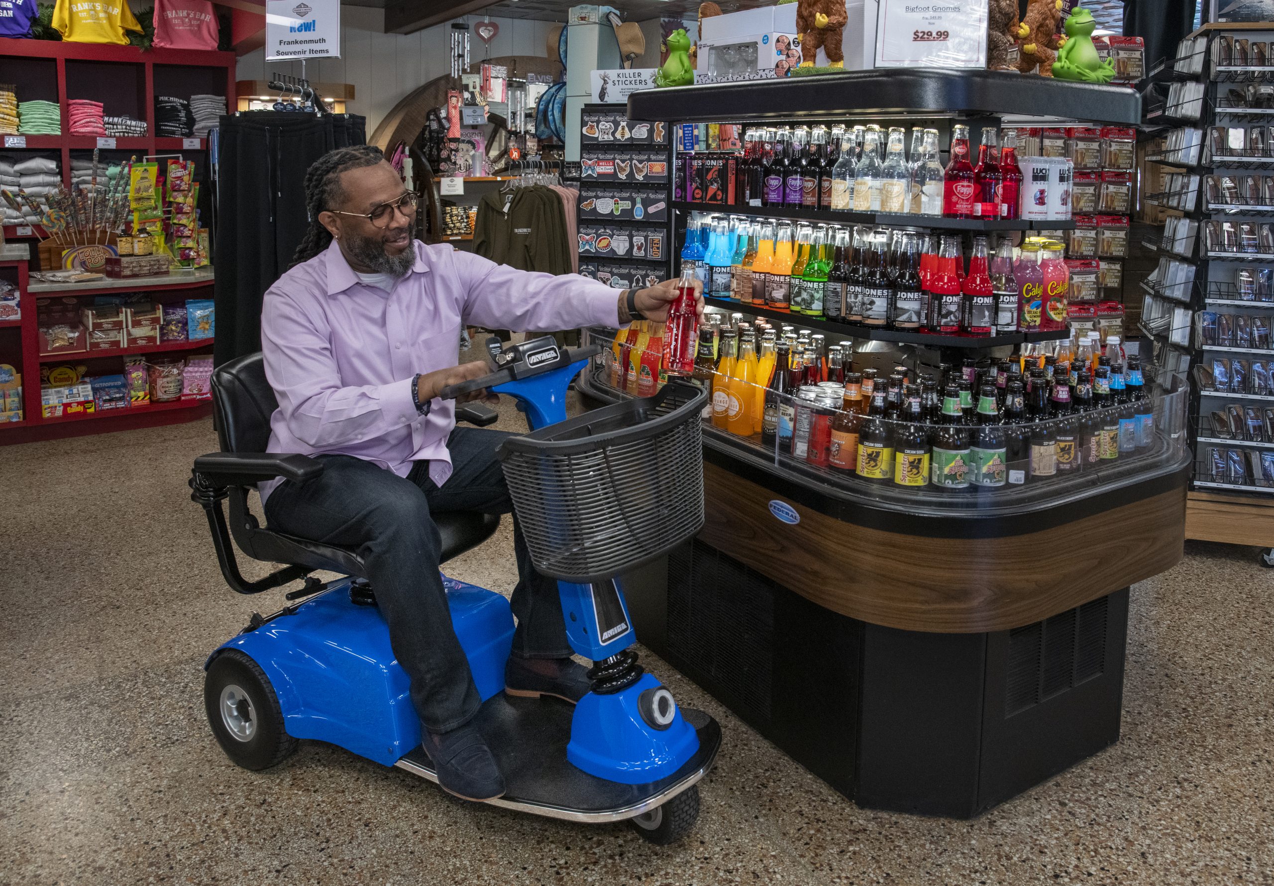 Man seated on an Amigo scooter shopping at a store.